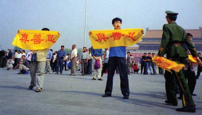Фалун Гонг практикуващи издигат бенери с надпис: "Истина, Доброта, Търпимост", преди полицията да ги арестува на пл. Тянанмън, Пекин, Китай.